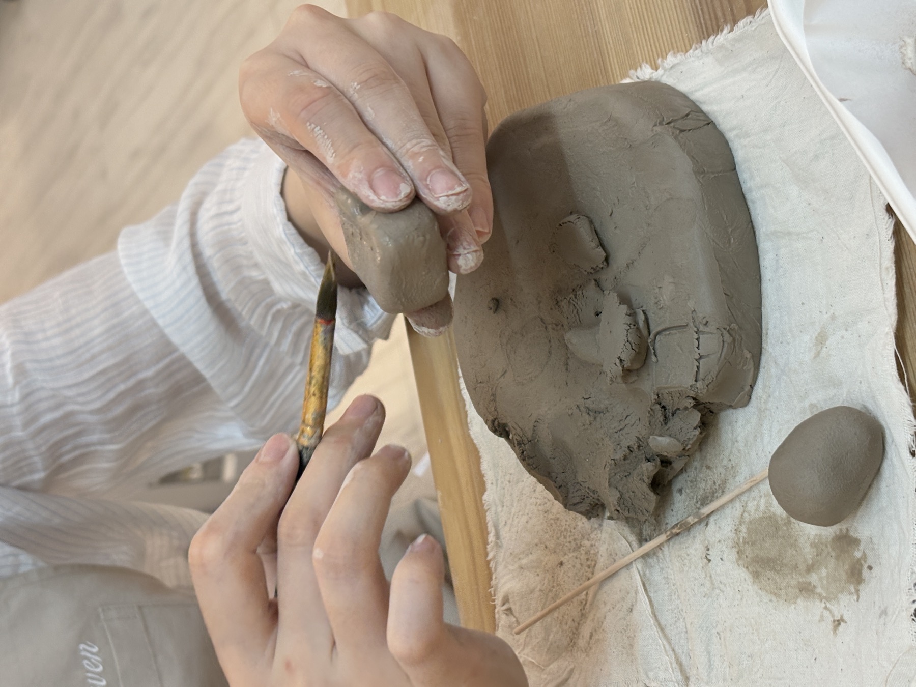 Hands shaping clay at MOR.NEVEN