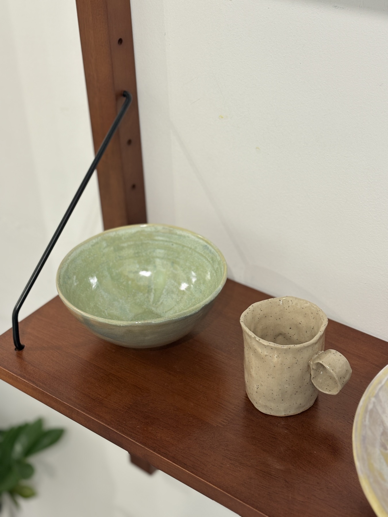 Green bowl and speckled mug on a shelf